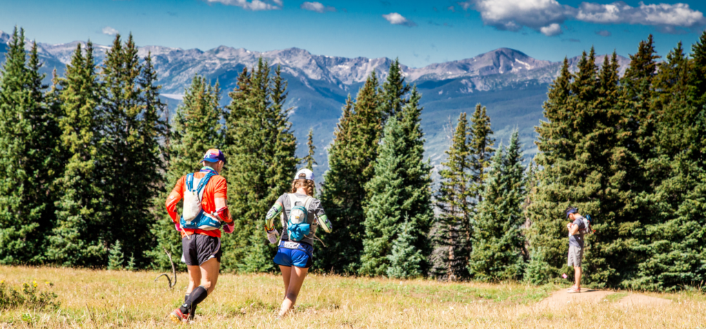 ultramarathon coaches Heather Hart and Geoff Hart running down a mountain trail 